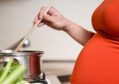 Pregnant woman cooking in kitchen